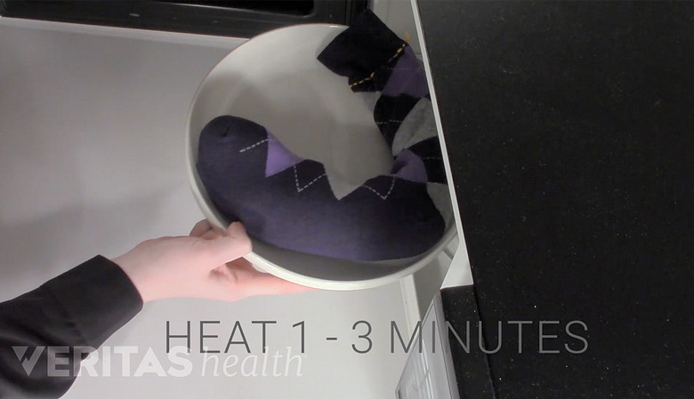 A sock heat pack being placed in the microwave for 1-3 minutes.